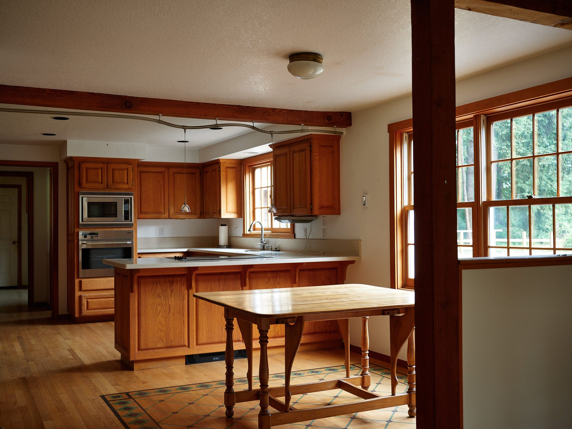 Kitchen with wood cabinetry, island, and a bright dining area
