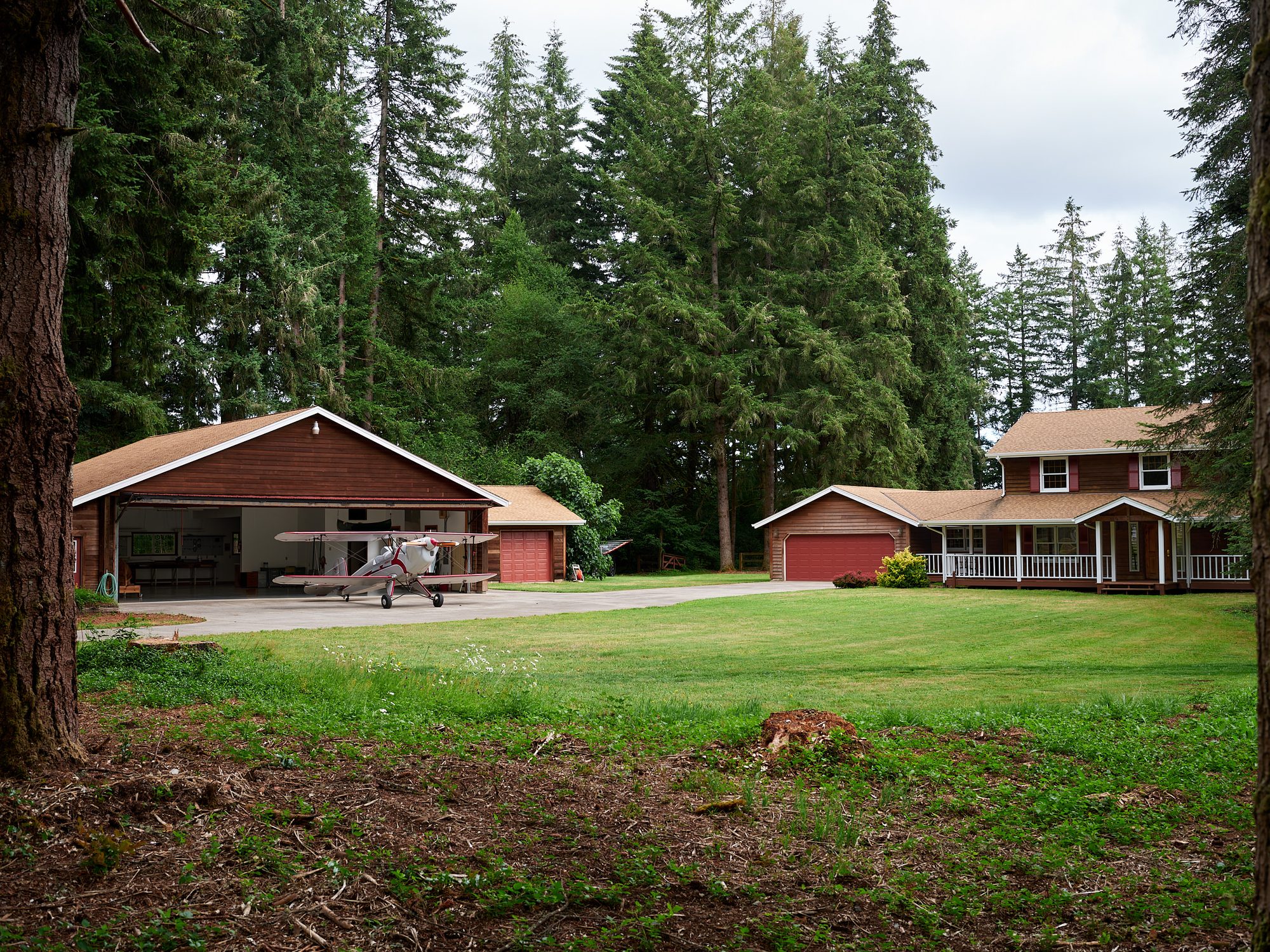 Wide view of the 2.71-acre property showing the home, hangar, and airplane
